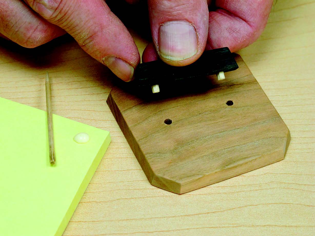 Join the handle to the lid with 1/8”-diameter dowel pins. They’re small, but they do the job. Use the blunted end of a round toothpick to apply glue.