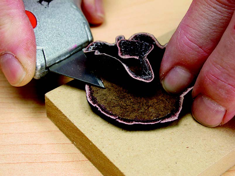 Cover the bottom insert with leather. The leather is adhered to the insert with spray adhesive. Use a utility knife to trim away the excess leather.