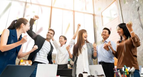 Multi-ethnic businesspeople cheering with business project successful in meeting room office backgroound